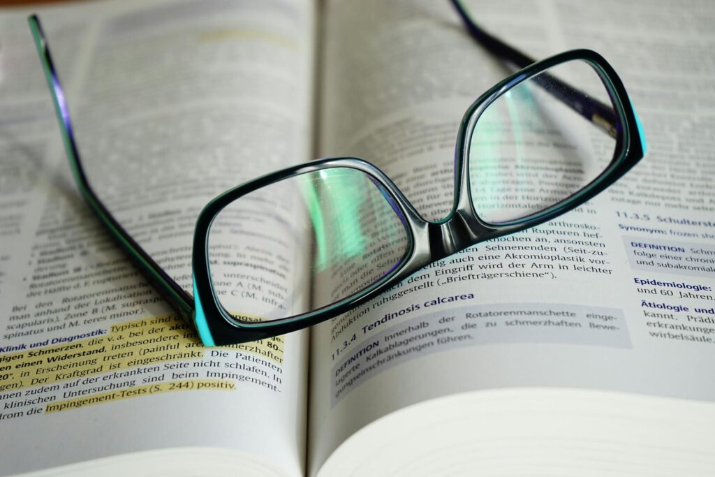 Open book with highlighted notes and glasses on top, symbolizing last-minute study and exam revision.